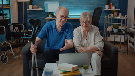 Senior people using laptop to talk to family on remote videoconference in living room. Aged woman...