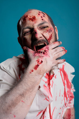 Spooky deadly zombie biting bloody hand with scars and wounds, being aggressive and dangerous....
