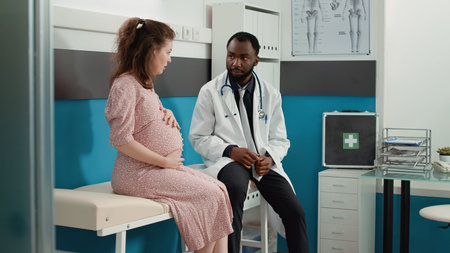 African american specialist consulting pregnant woman at checkup visit examination. General...