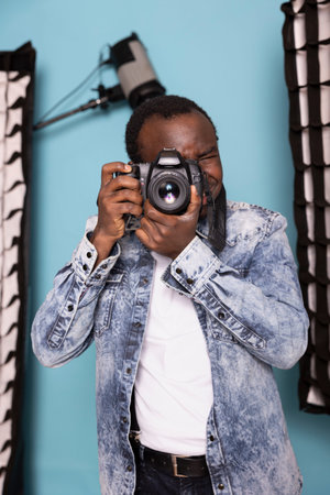 African american cameraman confidently uses his DSLR, demonstrating his photography skills. Focused...