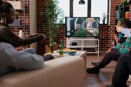 Diverse people playing video games competition on tv, enjoying shooting game play on console at...