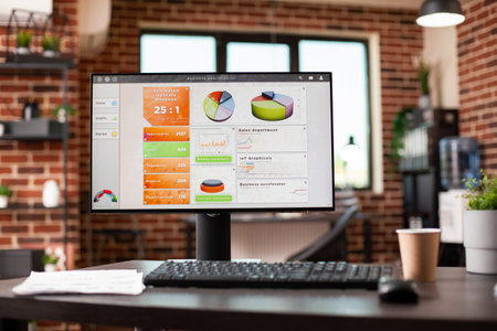 Brick wall office with desk prepared for presentations, holding a computer displaying analytics and...