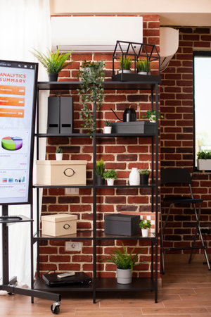 Office cabinet arranged with plant decorations and boxes as digital screen displays summary of...
