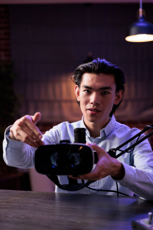 Online vlogger showing vr glasses on camera, filming product review and recommendation on live...