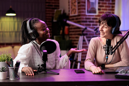 Team of happy content creators hosting online show in living room studio, shooting vlog using...