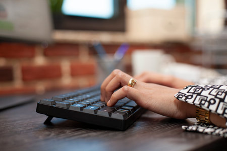 Closeup on the hands of a business person using keyboard on office desk. Female professional typing...