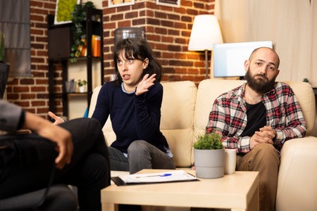 Annoyed husband and wife discussing problems with marriage counselor. Angry woman sharing emotional...