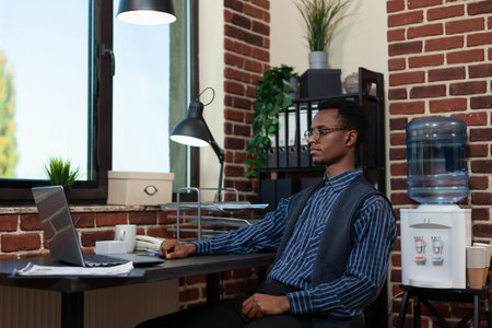 Entrepreneur sitting at desk in video call conference briefing about business results using laptop...