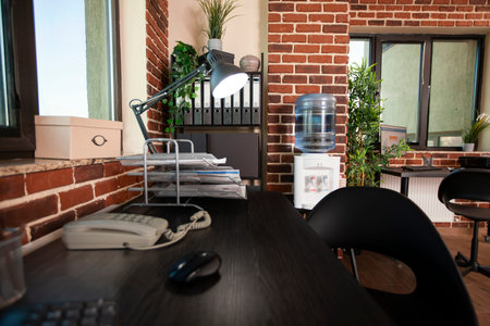 Tidy workspace with clean wooden desk arranged neatly for business preparation. Office cabinet...