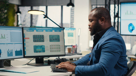Black male analyst focused on IT company development with digital tools, review analytics and...