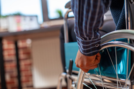 Selective focus on african american man in wheelchair rolling into his brick wall workspace, ready...