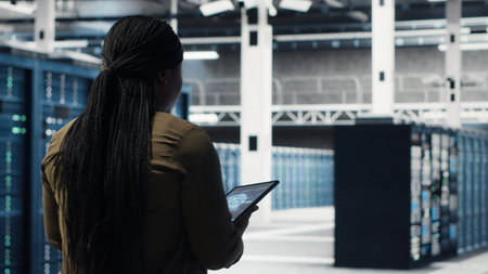 Data center software developer doing AI data analysis on tablet to upgrade infrastructure. Server...