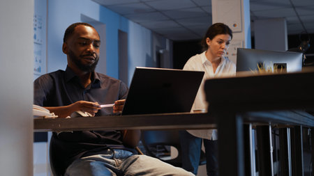 Executive manager attending online teleconference meeting on laptop, using laptop to talk on...