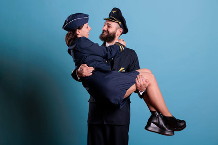 Pilot holding stewardess in arms, looking at each other portrait, aircrew in professional uniform....