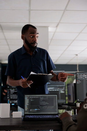 African american web developer analyzing html script on terminal window, using server database on...