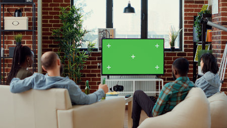 Diverse friends watching tv series on greenscreen template, using isolated mockup copyspace to watch...