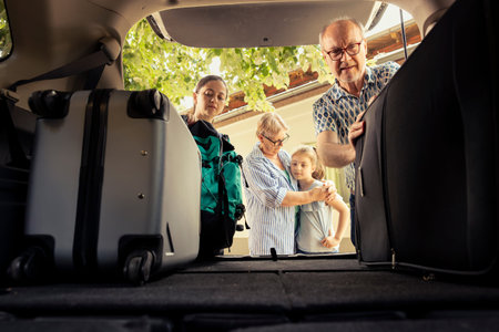 Little girl leaving on vacation with her grandparents and mother, feeling excited while the adults...