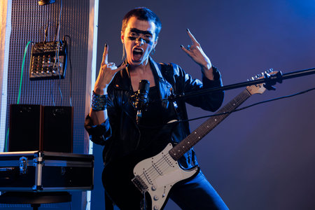Punk rocker doing rock sign on live performance, singing loud alternative heavy metal music. Using...