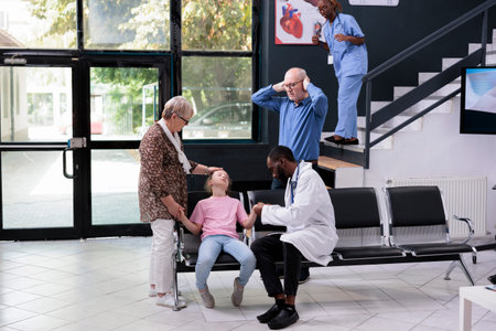 Unconscious little child falling on chair in hospital waiting area during checkup visit...