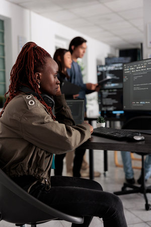 Pensive african american app developer programming code development trying to think at ideas to...