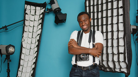 African american man having backstage photography equipment, using spotlight, flashlight, dslr...
