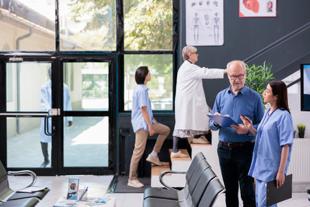 Medical assistant explaining disease expertise to elderly patient while discussing health care...