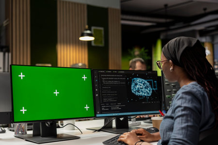 Programmer utilizing AI software on green screen PC to optimize performance and forecast issues. IT...