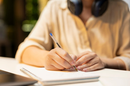 Close up of employee doing overtime and transcribing key points, writing information on a textbook....