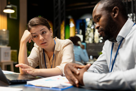 Manager in office evaluating staff performance with laptop, giving bad news to upset woman failing...