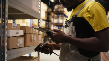 African american e-commerce employee scanning awb tracking numbers, registering shipping labels and...