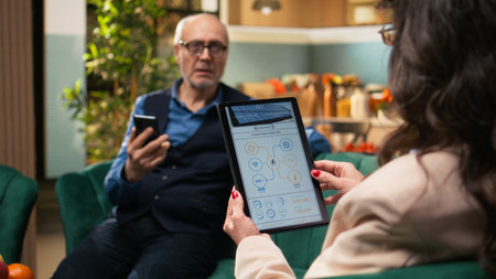 Senior woman holding tablet with green energy systems relaxing at home, healthy lifestyle together...