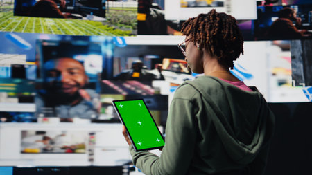 Green screen mockup tablet used by young woman watching content on video streaming services,...