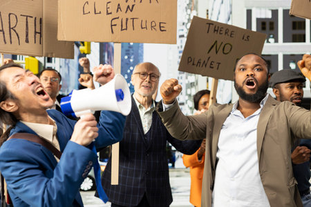 Group of activists and protestors attend climate strike and manifestation, marching together with posters to defend nature, environmental rights and sustainability. Global warming.
