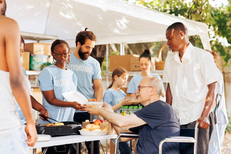Diverse individuals donate free food to needy offering helping hand in fight against hunger and poverty; volunteers provide support to homeless poor and disabled showcasing charitable efforts.
