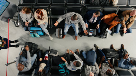 Agitated, top down view and gate agent giving delayed flights news to frustrated passengers in airport. Reacting to flight cancellation, announcement and annoyed group of multiethnic people