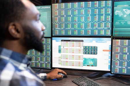 Financial analyst studying stock trading data at desk inside a financial workspace where screens, market data and portfolio decisions shape an active trading workflow.