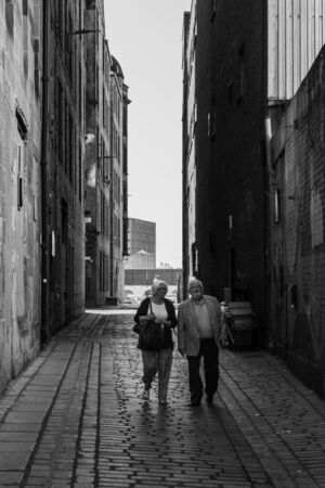 Couple walking through a Glasgow alleyway on a summers dayの写真素材