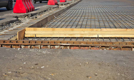 Renewal of the asphalt paving on the road  metal grid on the concrete baseの写真素材