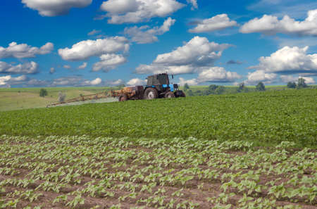 Tractor spraying the field on a sunny day