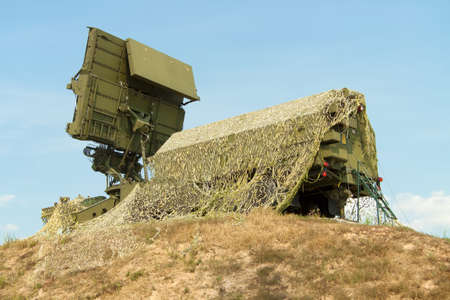 Mobile tactical air defense radar on position covered with a camouflage net