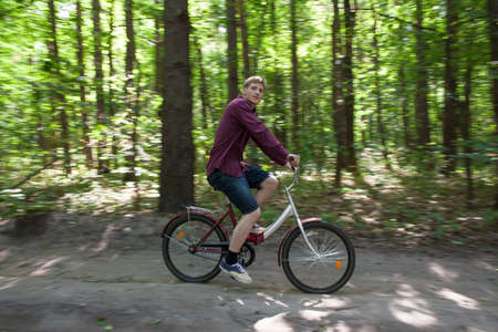 Young man riding his bike in the forestの写真素材