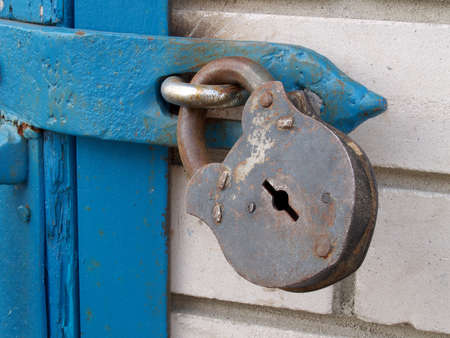 Old rusty lock hanging on the old doorの写真素材