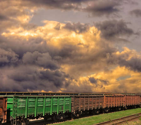 Cargo trains with sunset stormy clouds