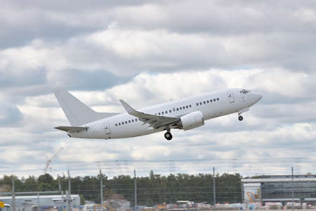 Passenger jet taking off from the airport with cloudy sky on the backgroundの写真素材