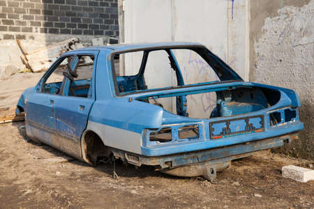 Disassembled car body standing near the garage gateの写真素材