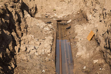 Hot water pipes breakage - open pit for repairingの写真素材
