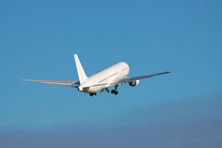 White airplane is taking off to the blue sky