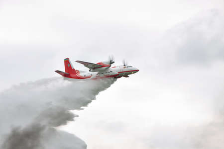 Nezhin, Ukraine - May 5, 2010: Ukrainian Emergency Service An-32P firefighter plane is dropping a load of water to extinguish the fire in the forestのeditorial素材