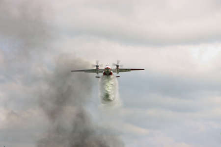 Nezhin, Ukraine - May 5, 2010: Ukrainian Emergency Service An-32P firefighter plane is dropping a load of water to extinguish the fire in the forestのeditorial素材