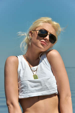 Pretty blonde girl posing on the beach in summerの写真素材